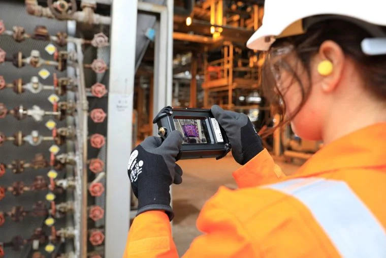 Profissional usando câmera FLIR em ambiente industrial