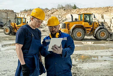 Profissionais analisam registros junto a equipamentos de mineração